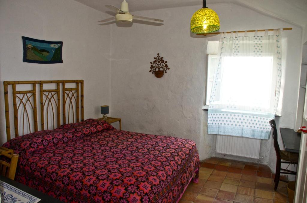 - une chambre avec un lit rouge et une fenêtre dans l'établissement Maison de Charme Giulietta, à Bonassola