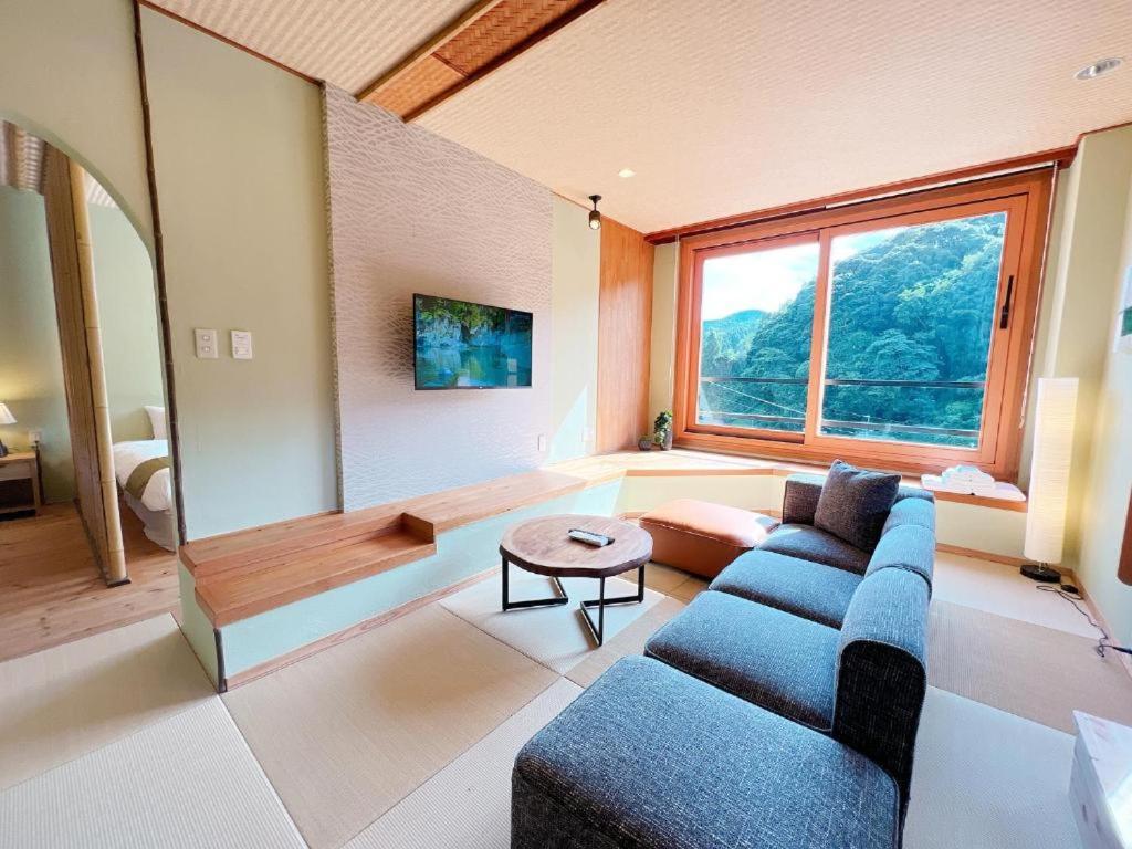un salon avec un canapé et une table dans l'établissement OWL RESORT ARIFUKU ONSEN, à Gotsu