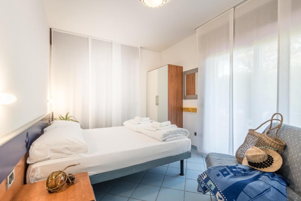 une petite pièce avec un lit et une chaise dans l'établissement Bosco Canoro Bibione Resort, à Bibione