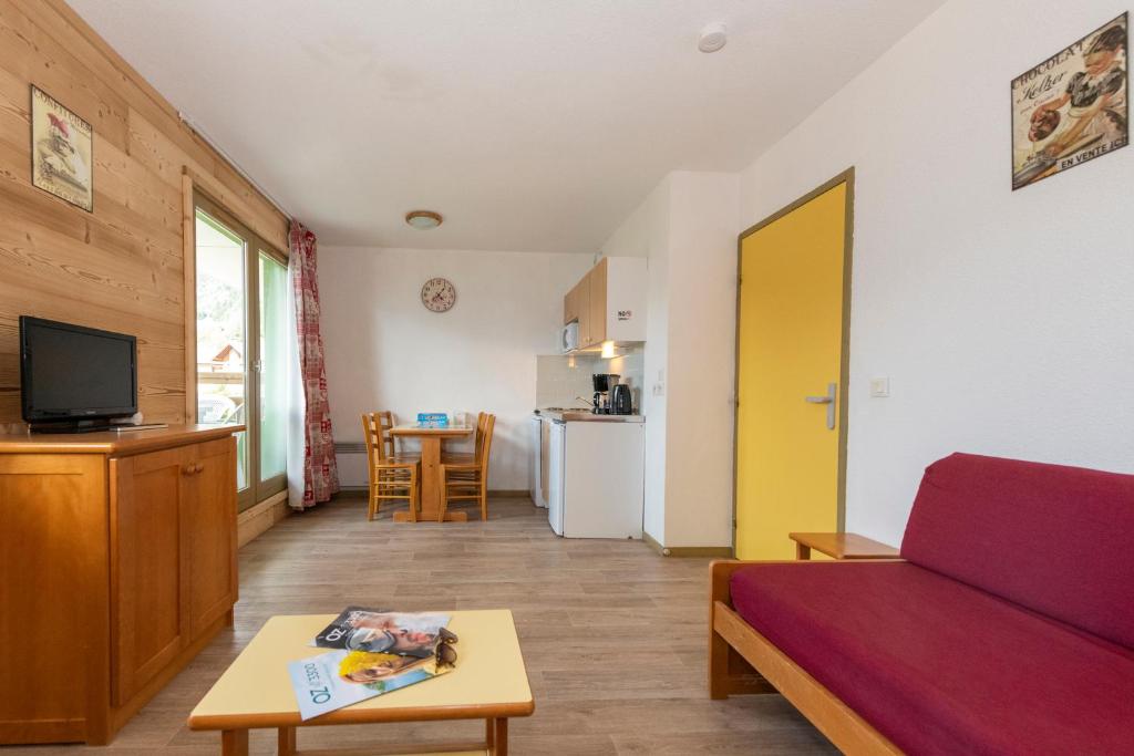 un salon avec un canapé et une table dans l'établissement Résidence Capfun Couleurs Soleil, Oz en Oisans, à Oz