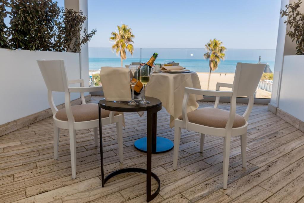 une table et des chaises sur une terrasse avec la plage dans l'établissement EUROPA Hotel, à Vasto