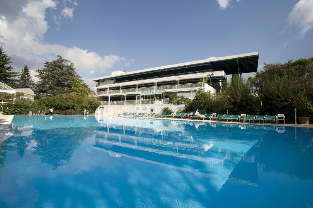 une grande piscine d'eau bleue devant un bâtiment dans l'établissement Hotel Sierra Silvana, à Selva di Fasano