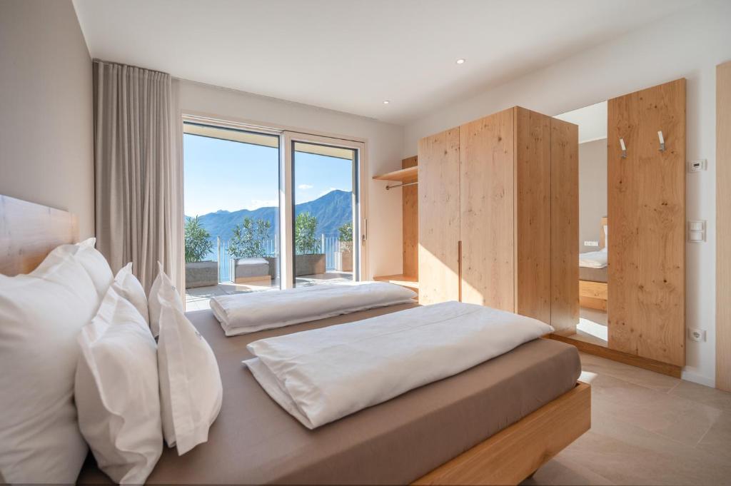 une chambre avec deux lits et une grande fenêtre dans l'établissement Villa Ca' Stella Lake Garda, à Brenzone