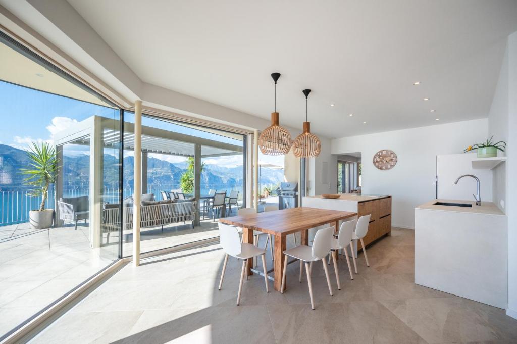 une cuisine et une salle à manger avec une table et des chaises en bois dans l'établissement Villa Ca' Stella Lake Garda, à Brenzone