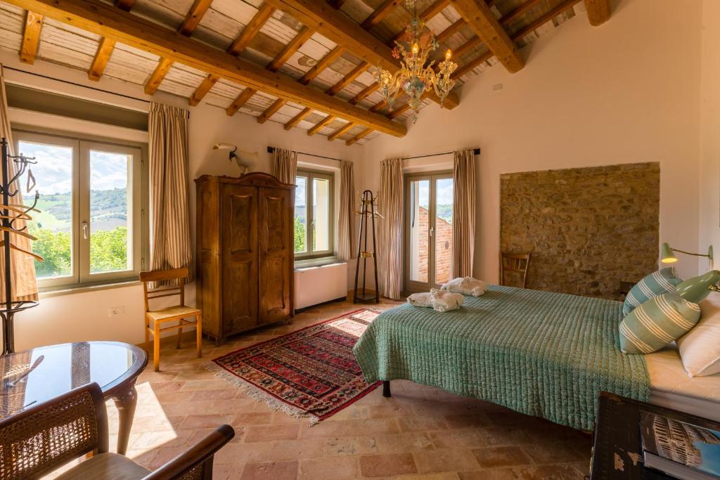 une chambre avec un lit, une table et des fenêtres dans l'établissement Villa Michela, à Barchi