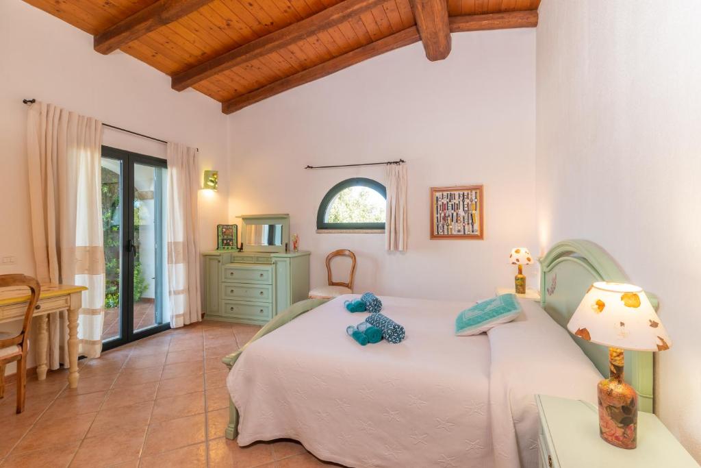 une chambre avec un lit et une table avec une lampe dans l'établissement Villa Monte Moro Azzi Russi, à Arzachena