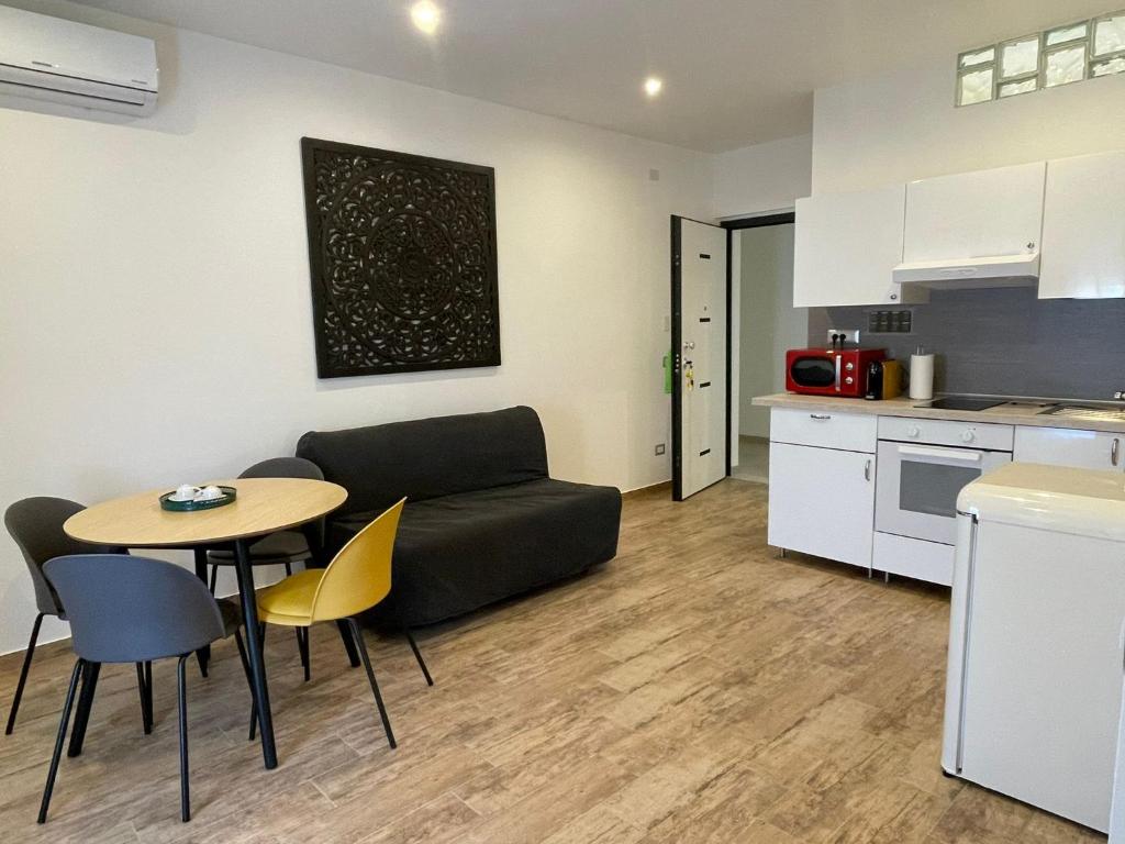 un salon avec un canapé et une table et une cuisine dans l'établissement Le Sirene Casa Vacanza, à Torvaianica