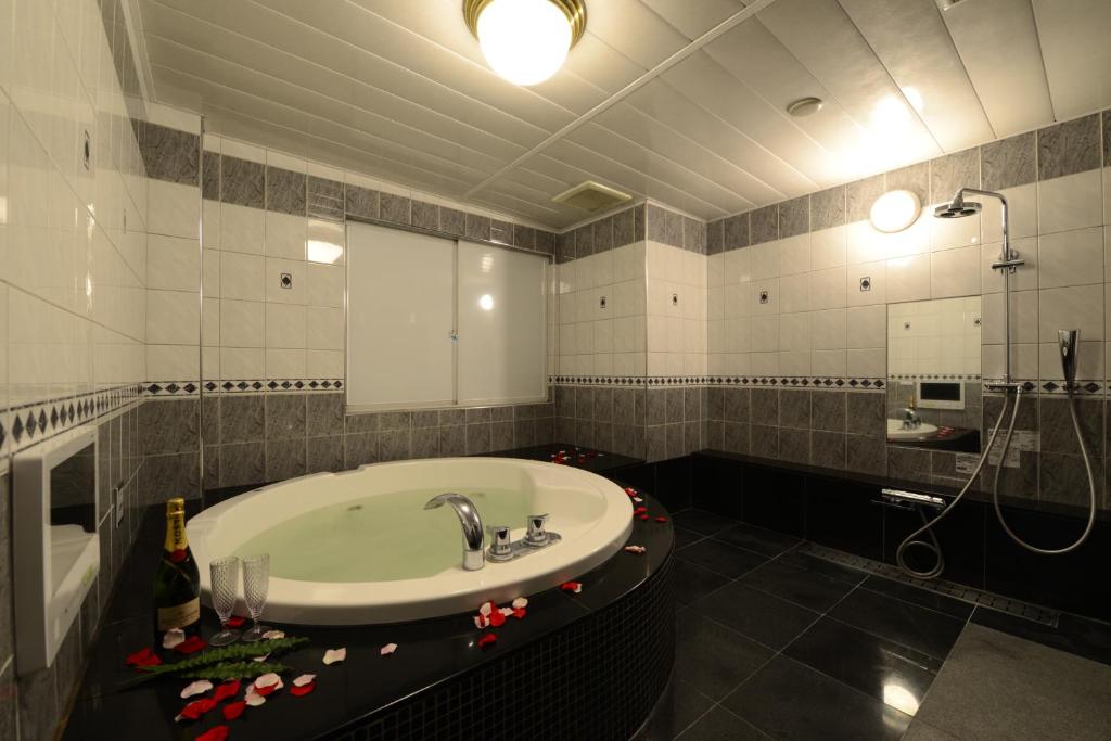 une salle de bain avec un lavabo et une baignoire dans l'établissement Hotel S-CUBE (Adult Only), à Bando