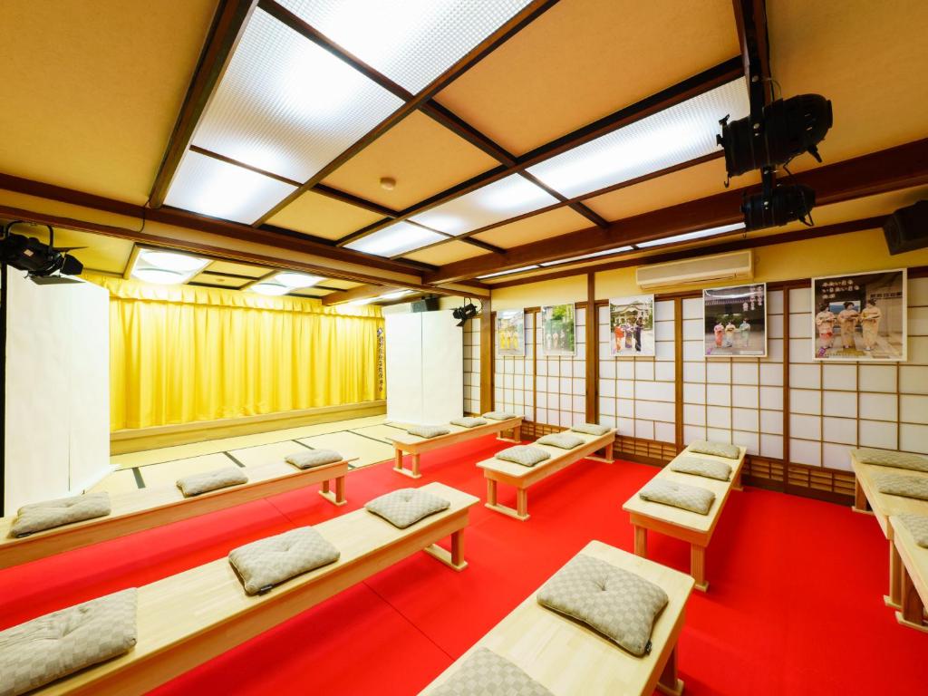 une salle avec une rangée de bancs et de tables dans l'établissement Ureshino Onsen Kotobukiya, à Ureshino