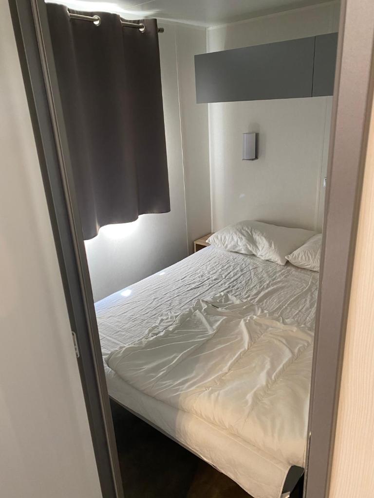 - un lit vide dans une petite pièce dans l'établissement Mobile home 5-pers Camping Leï Suves-Côtes d'Azur-including airco, à Roquebrune-sur Argens 37 autres photos
