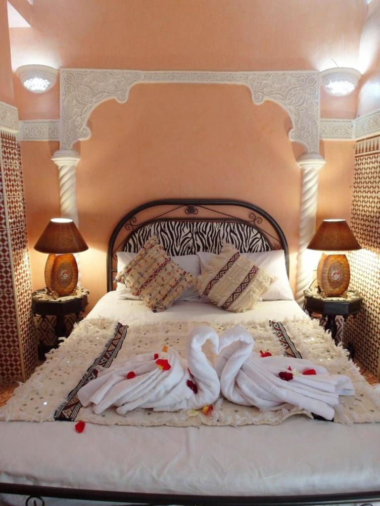 - une chambre avec 2 serviettes de cygne sur un lit dans l'établissement Riad Chennaoui, à Marrakech