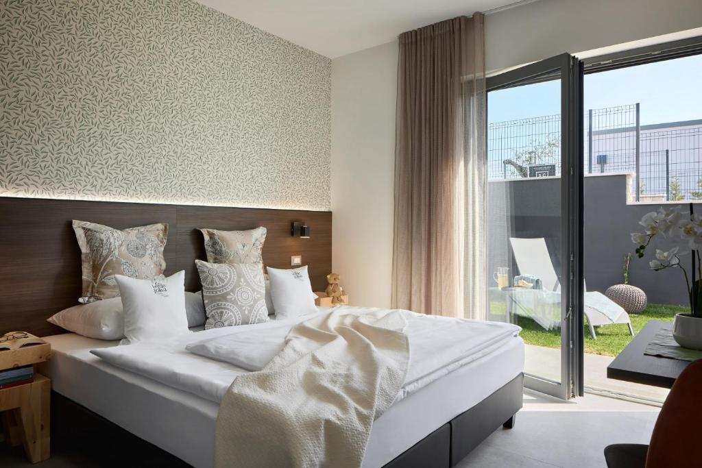 une chambre avec un lit avec des draps blancs et des oreillers dans l'établissement Ca'Verde Oliva, à Costermano 26 autres photos