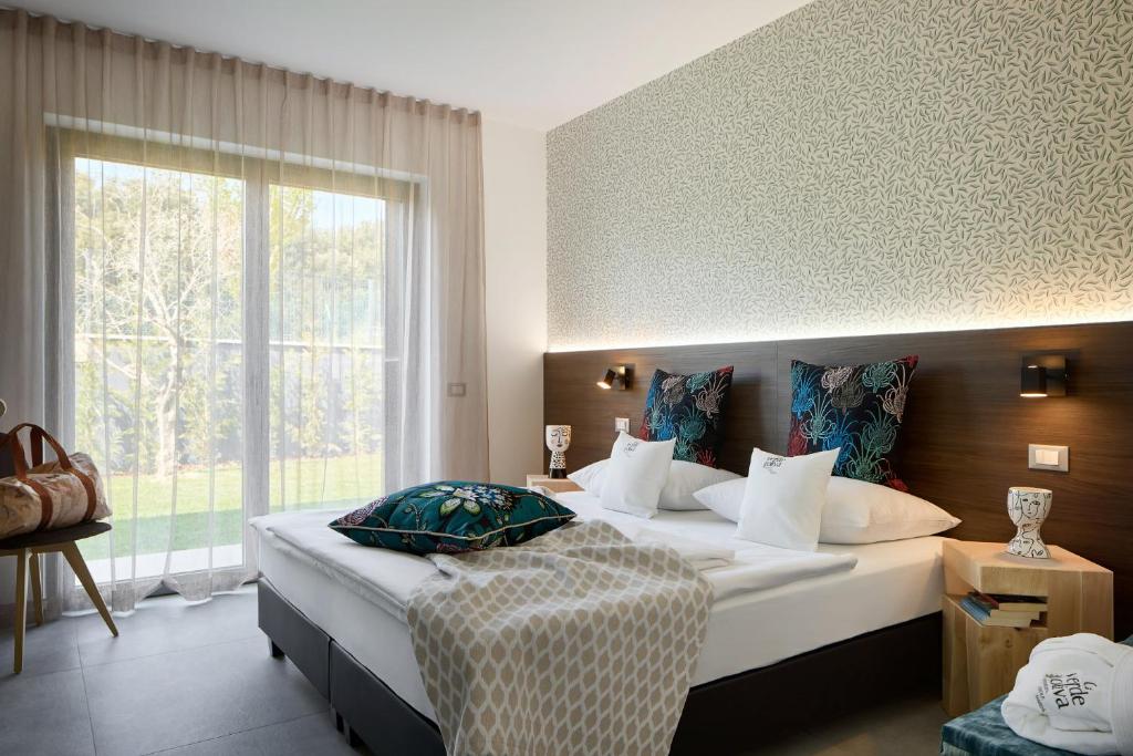 une chambre avec un lit et une grande fenêtre dans l'établissement Ca'Verde Oliva, à Costermano