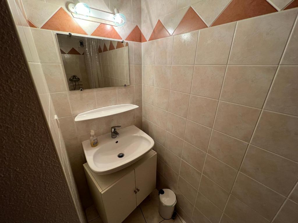 une petite salle de bain avec un lavabo et un miroir dans l'établissement Charmant duplex pied de pistes Briançon, à Briançon 4 autres photos