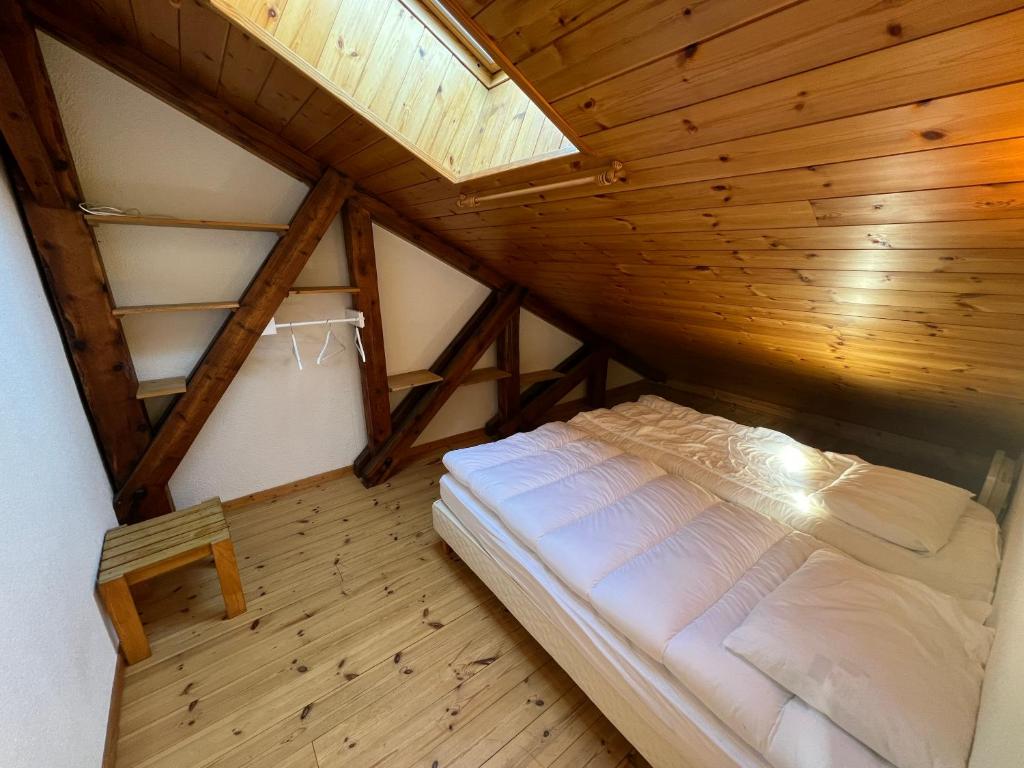 un lit dans une chambre avec un plafond en bois dans l'établissement Charmant duplex pied de pistes Briançon, à Briançon