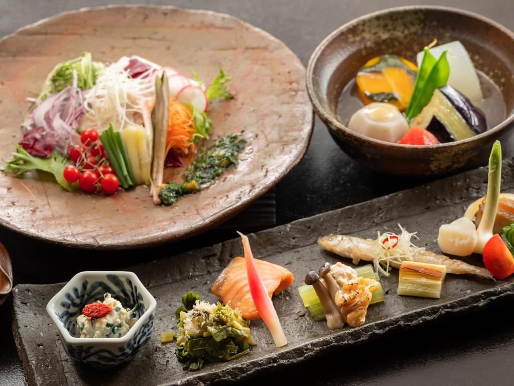une table avec deux assiettes de nourriture sur dans l'établissement Hakkei, à Maniwa