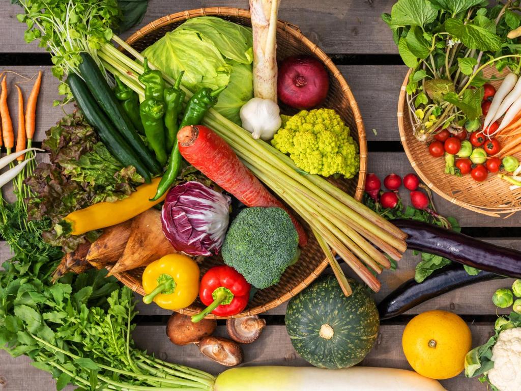un paquet de légumes dans des paniers sur une table en bois dans l'établissement Hakkei, à Maniwa