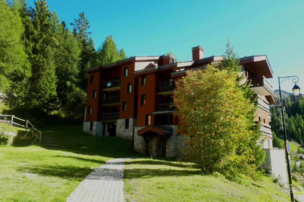 un bâtiment sur une colline avec un chemin devant lui dans l'établissement Apt With Garden In La Plagne, à La Plagne