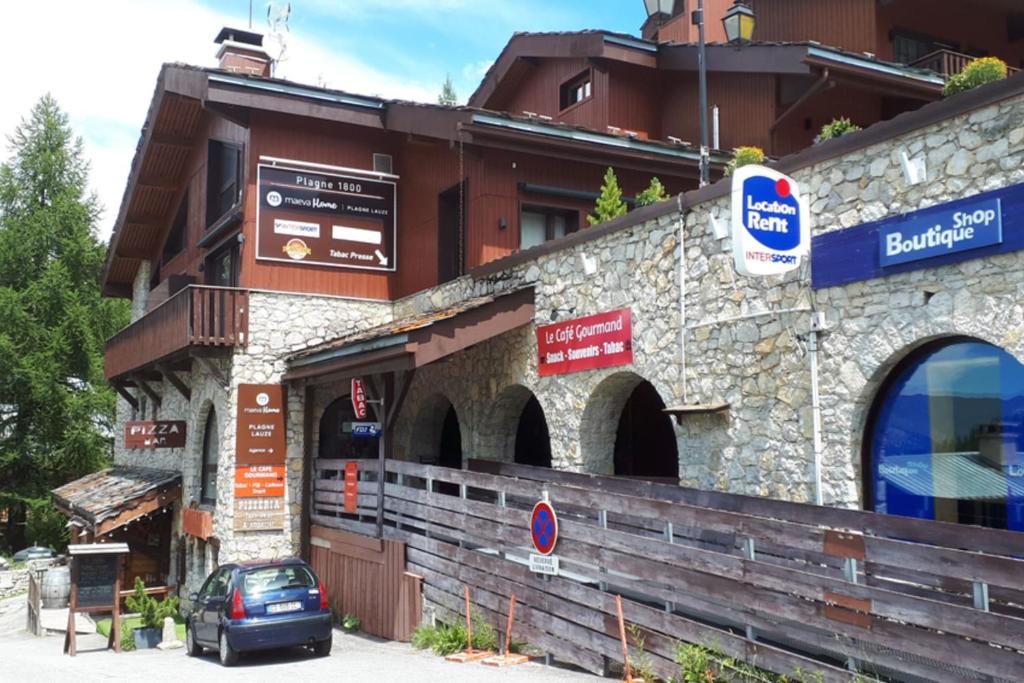 un bâtiment avec une voiture garée devant dans l'établissement Apt With Garden In La Plagne, à La Plagne