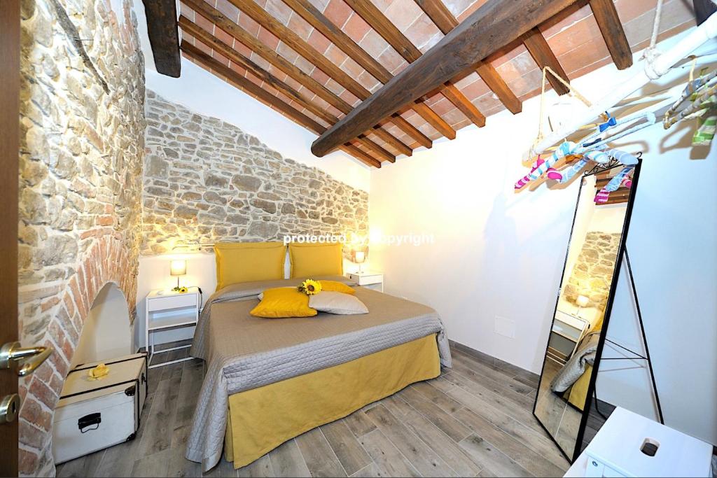 une chambre avec un lit et un mur en pierre dans l'établissement Romantic Lux Country House, à Monte San Savino
