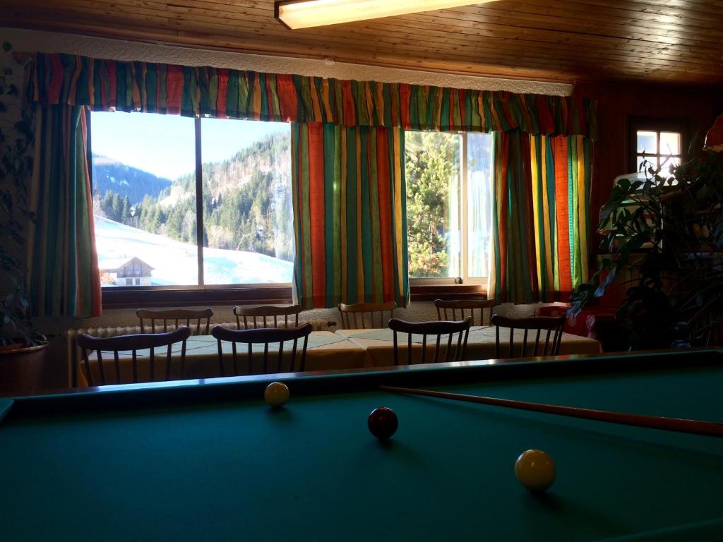 une salle de billard avec un billard et des chaises dans l'établissement Chalet-Hôtel du Borderan, à La Clusaz