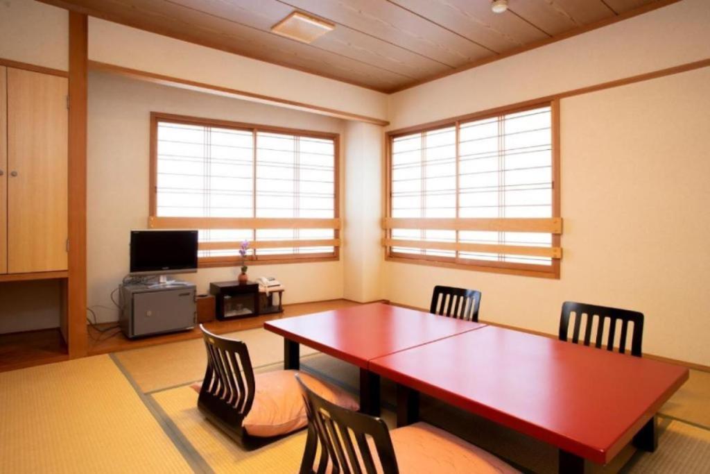une salle à manger avec une table et des chaises en bois dans l'établissement Saigiku, à Iwaki