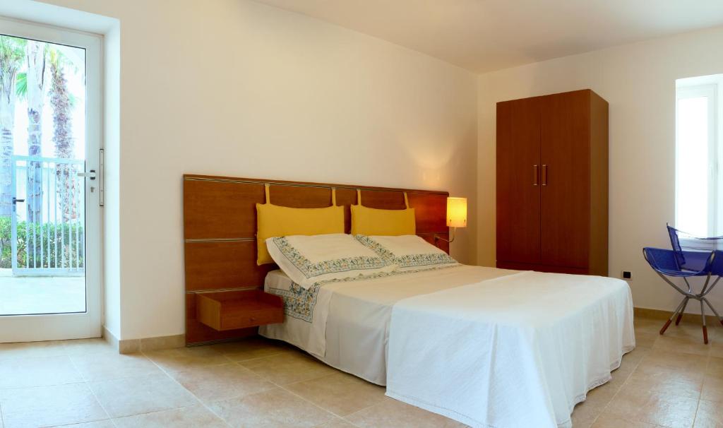 - une chambre avec un grand lit et une porte coulissante en verre dans l'établissement Vele del Pizzo - piscina, à Gallipoli 20 autres photos