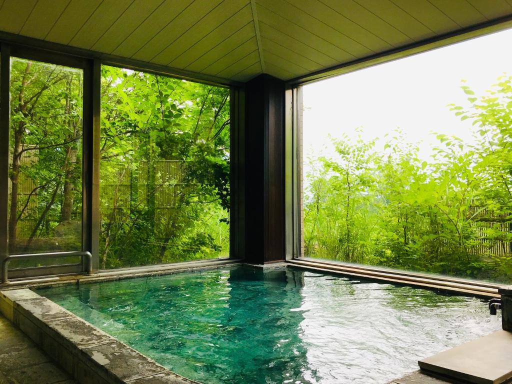 - une piscine dans une maison avec fenêtres dans l'établissement Lake Side Nikko Hotel, à Nikkō