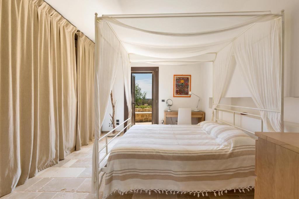 une chambre avec un lit à baldaquin avec rideaux dans l'établissement Villa Elaion by Perle di Puglia, à Marina di Pescoluse 73 autres photos
