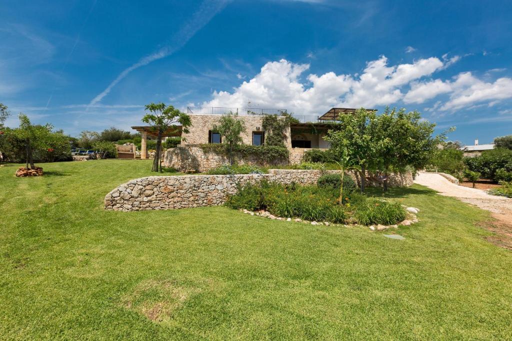 une maison sur une colline avec une cour verte dans l'établissement Villa Elaion by Perle di Puglia, à Marina di Pescoluse