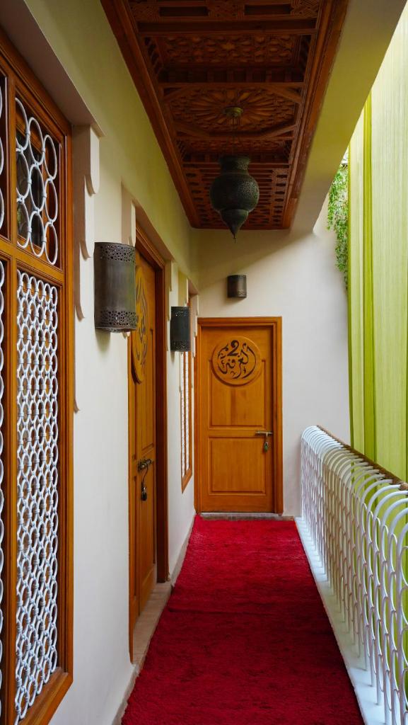 - un couloir avec une moquette rouge et une porte en bois dans l'établissement MAISON MK Adults ONLY - Music Riad, à Marrakech