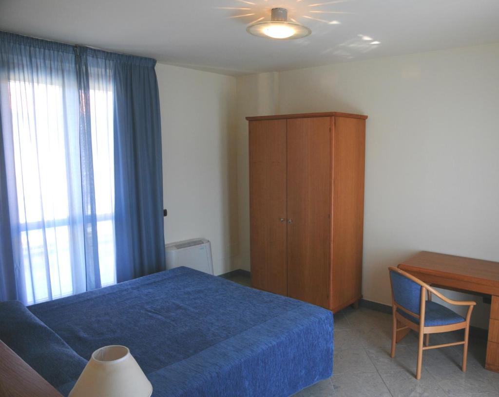 - une chambre avec un lit, une armoire en bois et un bureau dans l'établissement Continental Resort, à Tirrenia