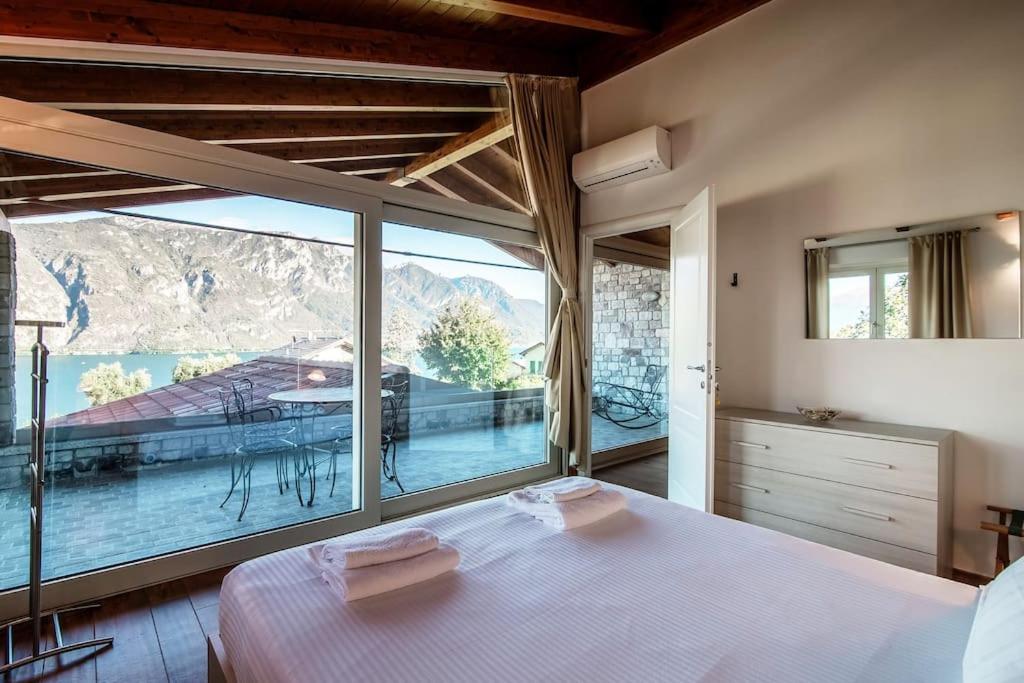 une chambre avec un lit et une grande fenêtre dans l'établissement Villa Sissi, à Bellagio