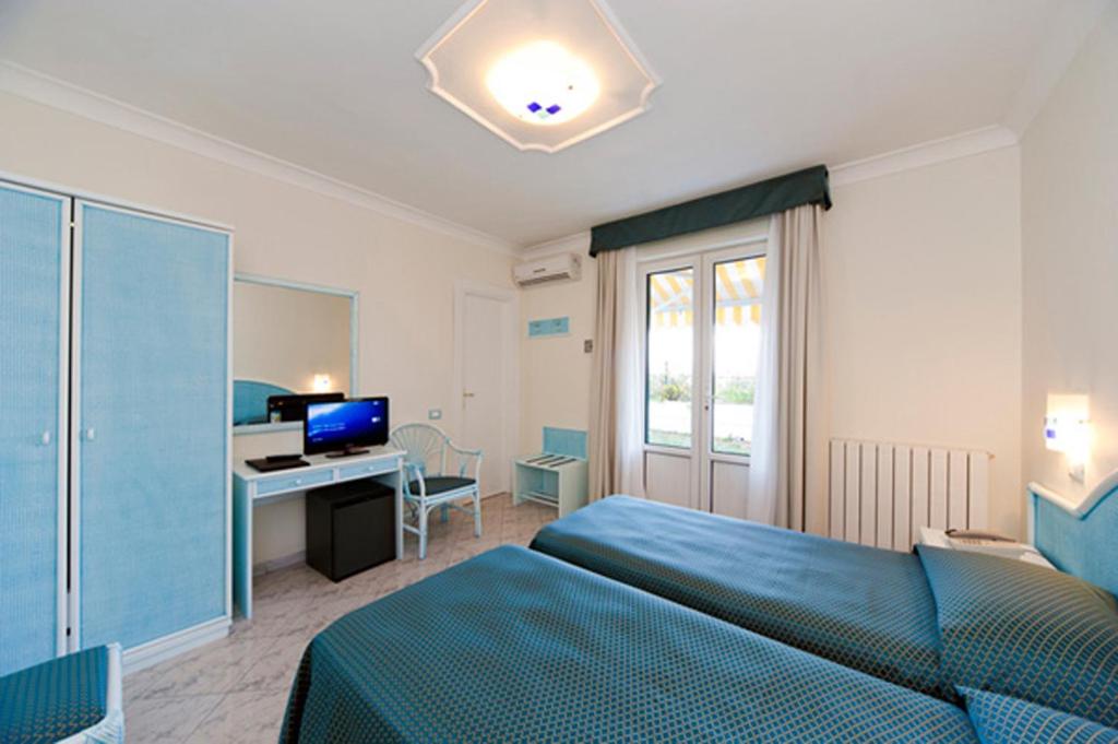 une chambre avec un lit et un bureau avec un ordinateur dans l'établissement Hotel Bellevue Benessere & Relax, à Ischia