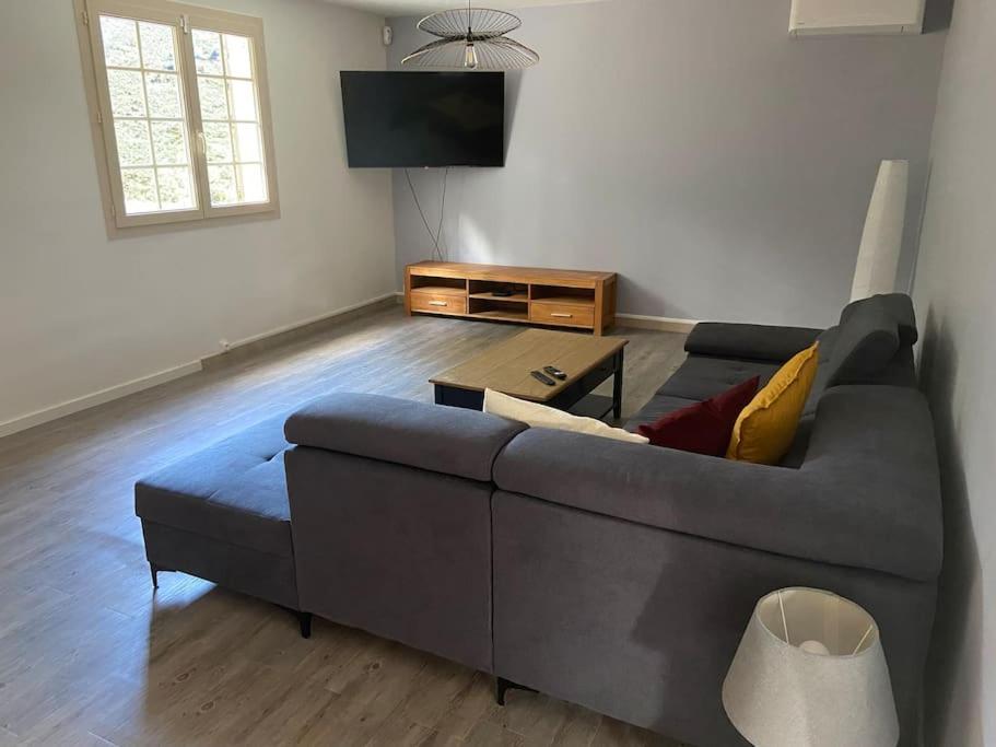 un salon avec un canapé et une télévision dans l'établissement Maison proche du Lac du Salagou, à Clermont-lʼHérault