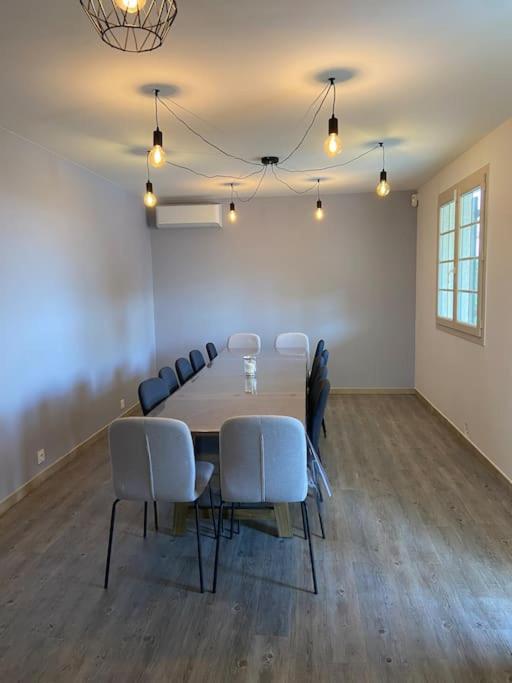 d'une salle de conférence avec une table et des chaises. dans l'établissement Maison proche du Lac du Salagou, à Clermont-lʼHérault 33 autres photos