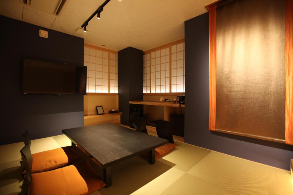 une pièce avec une table et des chaises et une cuisine dans l'établissement Kashoutei Hanaya, à Noboribetsu