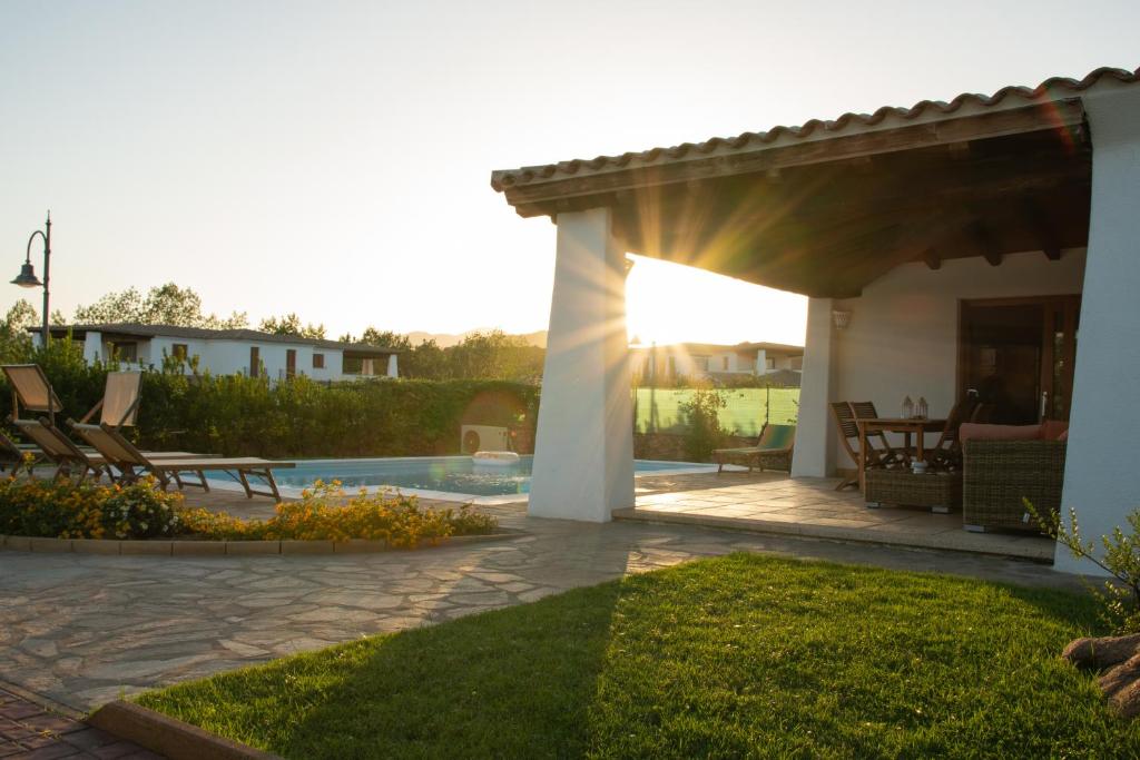 une terrasse avec une pergola et une piscine dans l'établissement Capannizza Villas, à Budoni