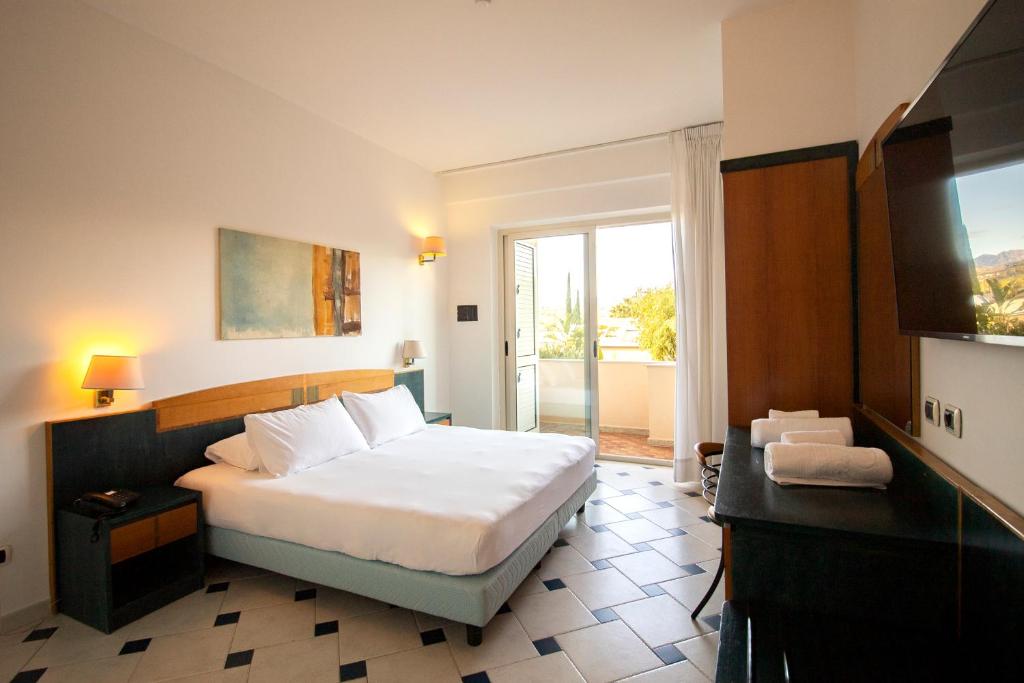 une chambre d'hôtel avec un lit et une télévision dans l'établissement Grand Hotel President, à Siderno Marina