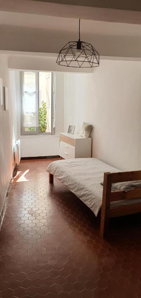 une chambre avec un lit et un lustre dans l'établissement Charmant appartement centre-ville 70m2, à Digne-Les-Bains