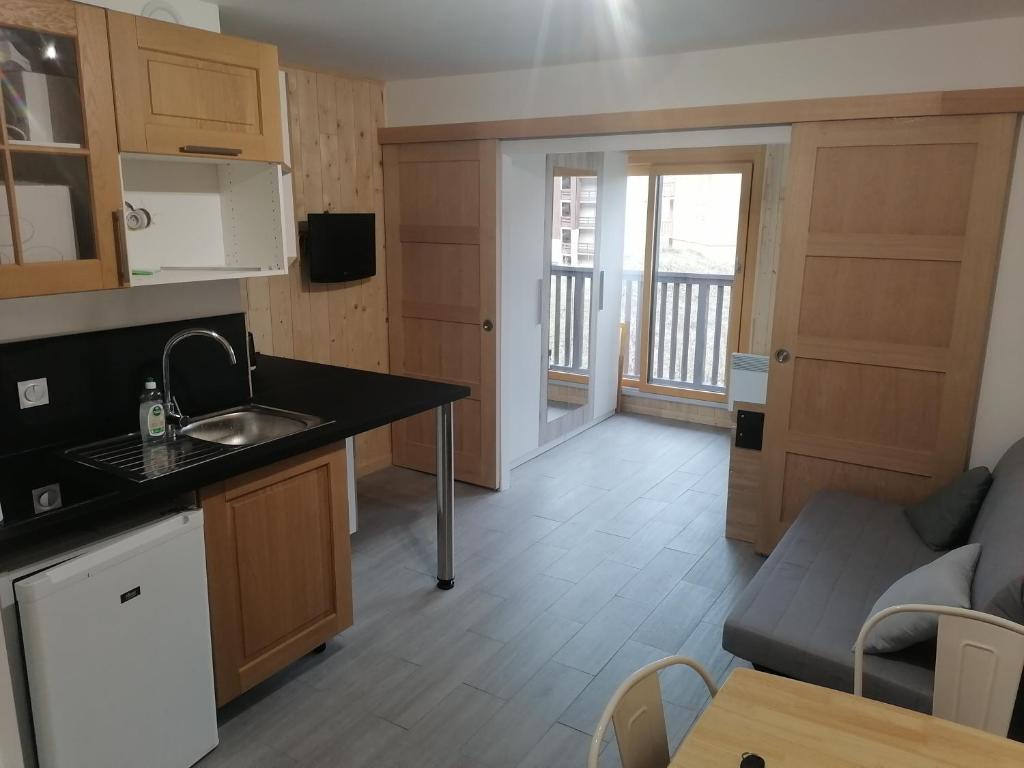 Il dispose d'une cuisine et d'un salon avec un évier et un canapé. dans l'établissement Appartement plein sud, Val Thorens Centre, à Val Thorens