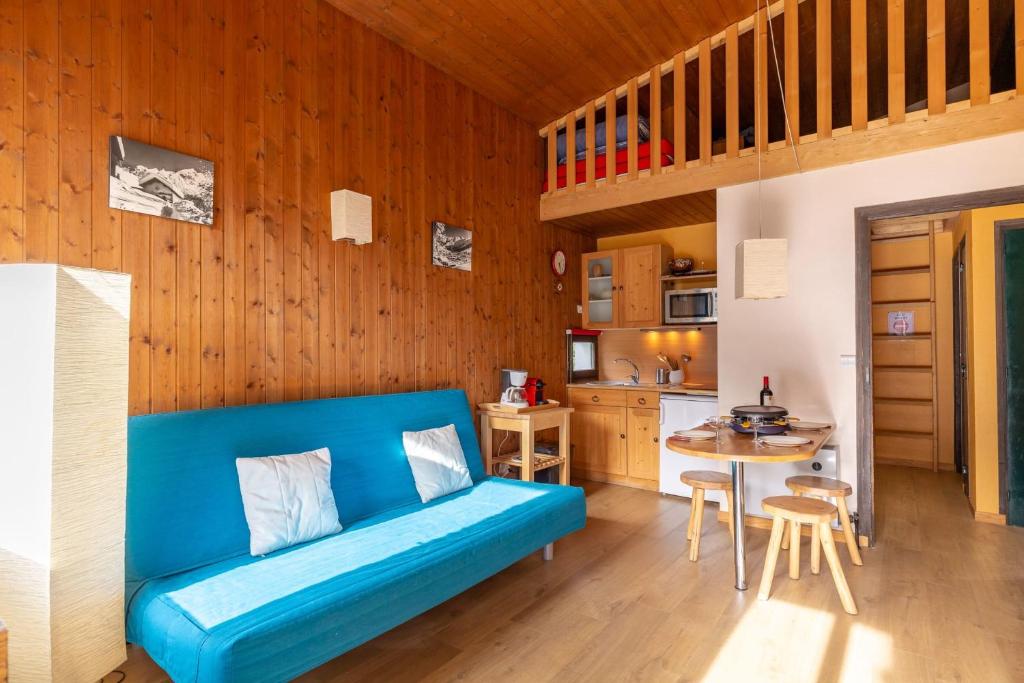 - un canapé bleu dans une chambre avec cuisine dans l'établissement Apartment with balcony close to the slopes, à La Clusaz