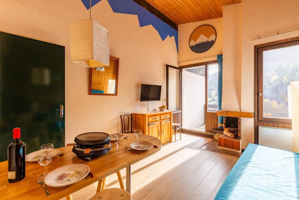 - un salon avec une table et un pot dans l'établissement Apartment with balcony close to the slopes, à La Clusaz