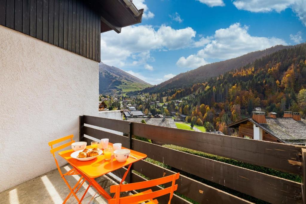 une table et des chaises sur un balcon avec vue dans l'établissement Apartment with balcony close to the slopes, à La Clusaz