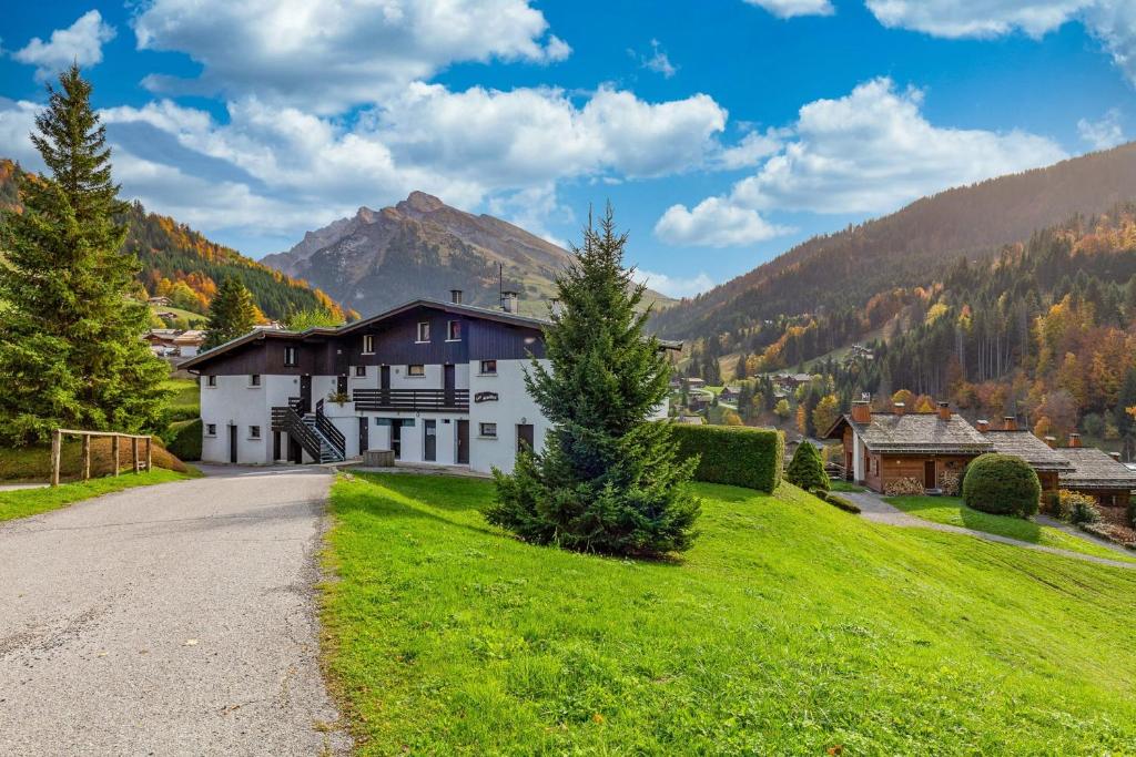 une maison sur une colline verdoyante avec une route dans l'établissement Apartment with balcony close to the slopes, à La Clusaz 3 autres photos