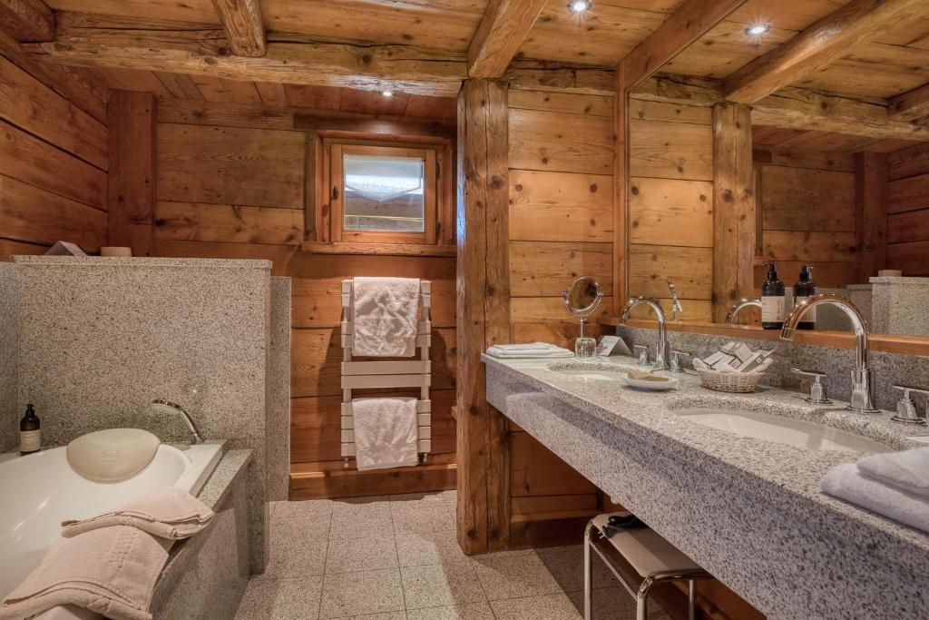 une salle de bain avec deux lavabos et une baignoire dans l'établissement Hôtel Les Servages d'Armelle, aux Carroz d'Arâches 37 autres photos