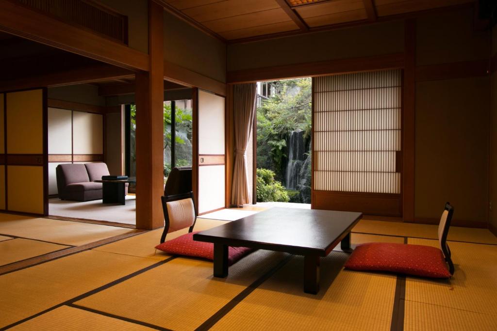 une pièce avec une table, des chaises et une fenêtre dans l'établissement Beautiful Japanese Garden Kagetsu, à Fuefuki