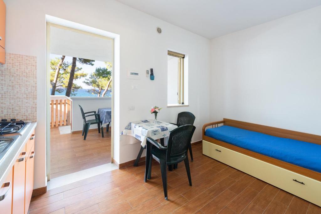 Cette petite chambre comprend un lit et une table avec des chaises. dans l'établissement Sfinal Residence, à Peschici