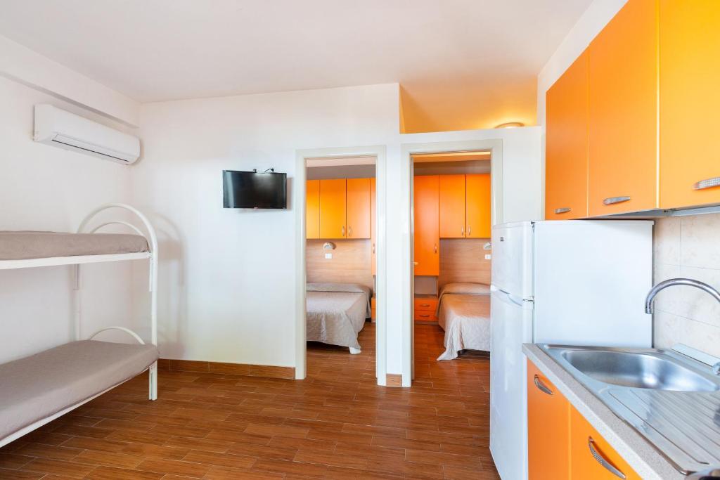 Cette petite chambre comprend une cuisine équipée d'un évier et d'un réfrigérateur. dans l'établissement Sfinal Residence, à Peschici
