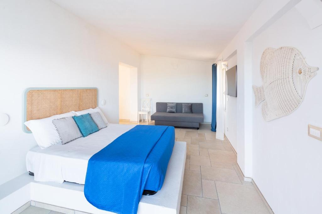- une chambre blanche avec une couverture bleue sur un lit dans l'établissement Sfinal Residence, à Peschici 60 autres photos
